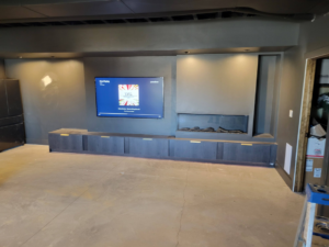 A newly installed media console with a mounted TV and electric fireplace by Joe Norton's Handyman Service in Williston, ND.