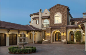 A Mediterranean-style custom home exterior with stone accents and a fountain by Cornerstone Custom Construction LLC in Beaver Falls, PA