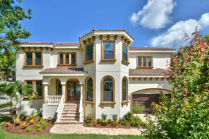 A beautiful Mediterranean-style home exterior with a tiled roof and arched windows, constructed by TamLin Homes Inc in Tampa, FL