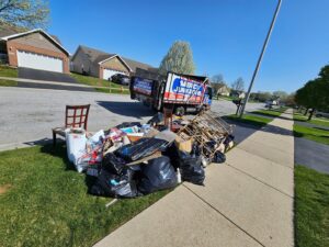 A large pile of household junk and debris on a lawn awaiting pickup by Merica JunkBoss LLC in Gary, IN.