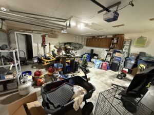 A very messy garage filled with tools, boxes, and household items, awaiting cleanout by Clear Your Junk - Pearland, Houston, TX.