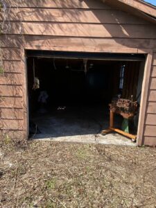 A messy garage or shed interior before a cleanout service by Port City Remove and Improve in Wilmington, NC