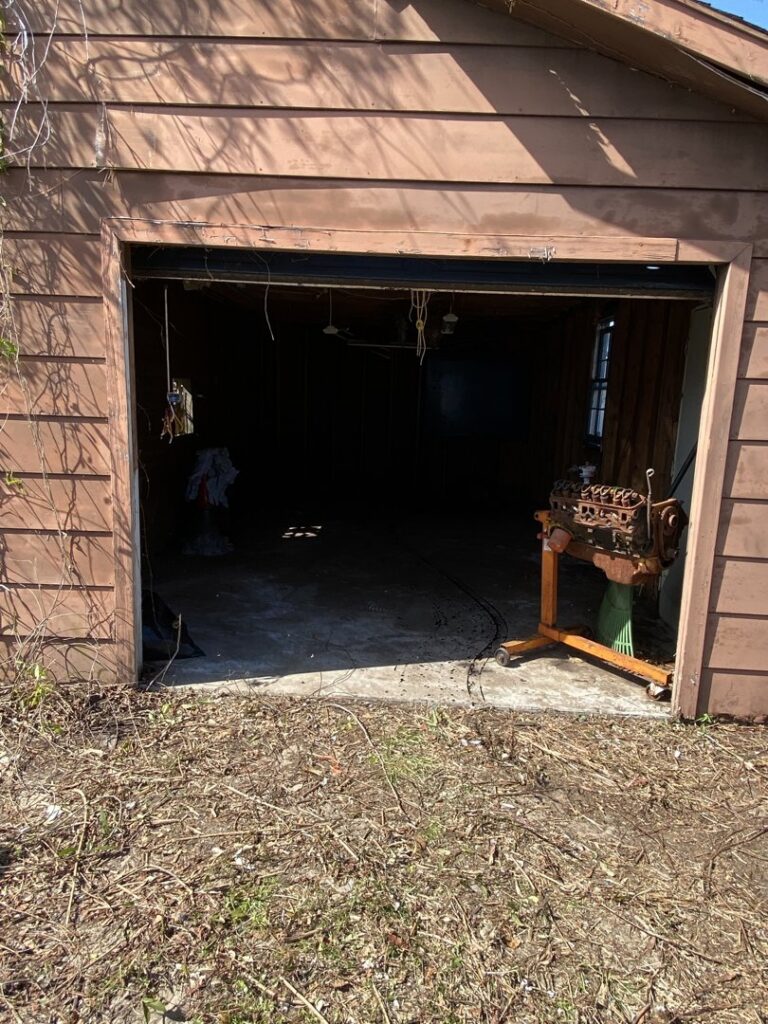 A messy garage or shed interior before a cleanout service by Port City Remove and Improve in Wilmington, NC