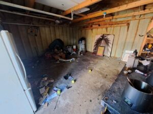 A messy garage or storage area with various items on the floor, ready for junk removal by CC JUNK Removal in Corpus Christi, TX.