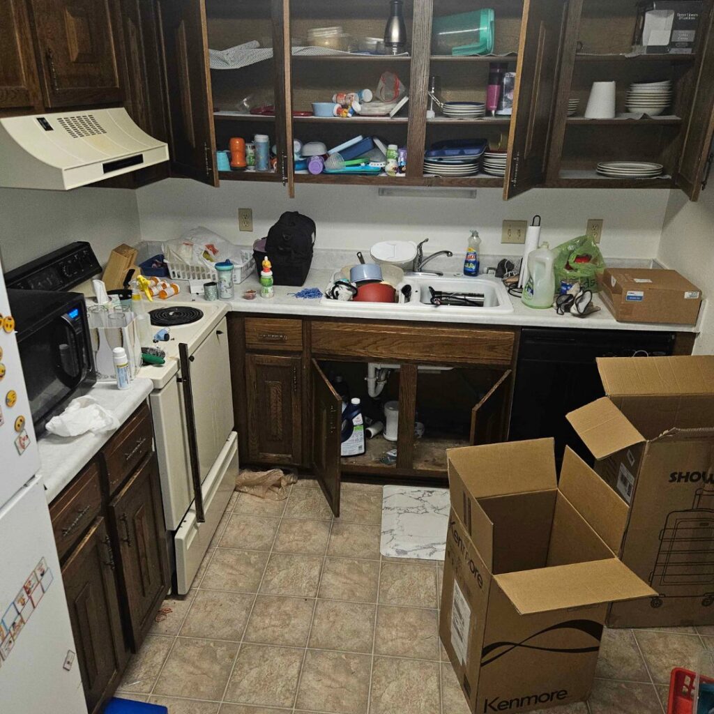A messy kitchen with items on counters and open cabinets, indicating a cleanout job for Midwest Removal in Omaha, NE.