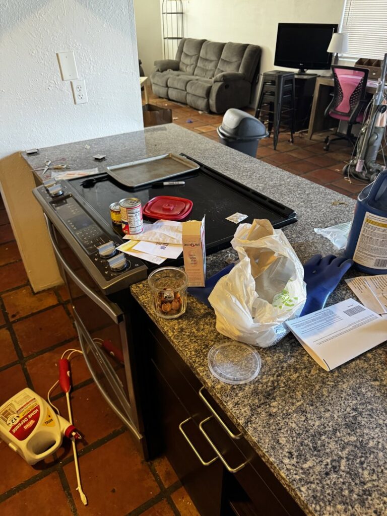 A messy kitchen counter with dirty dishes and scattered items, indicating a junk removal service by Affinity Bio Solutions in Phoenix, AZ.