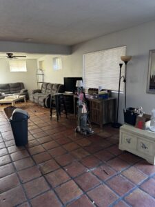 A messy living room with scattered items and dirty floors, representing a space ready for junk removal by Affinity Bio Solutions in Phoenix, AZ.