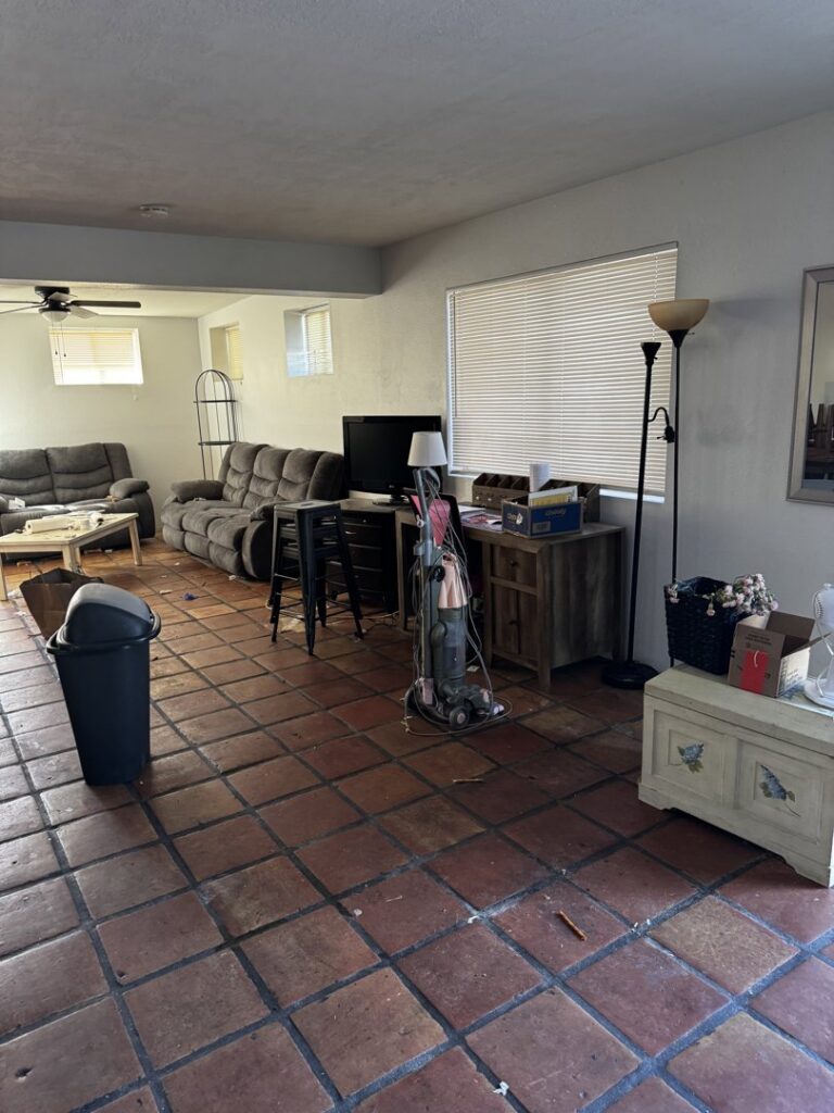 A messy living room with scattered items and dirty floors, representing a space ready for junk removal by Affinity Bio Solutions in Phoenix, AZ.