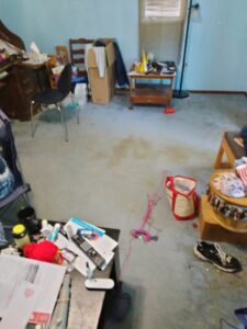 A messy room with various items scattered on the floor, indicating a space requiring a cleanout service from KJ Haul Away Junk Removal in Cedar Rapids, IA.