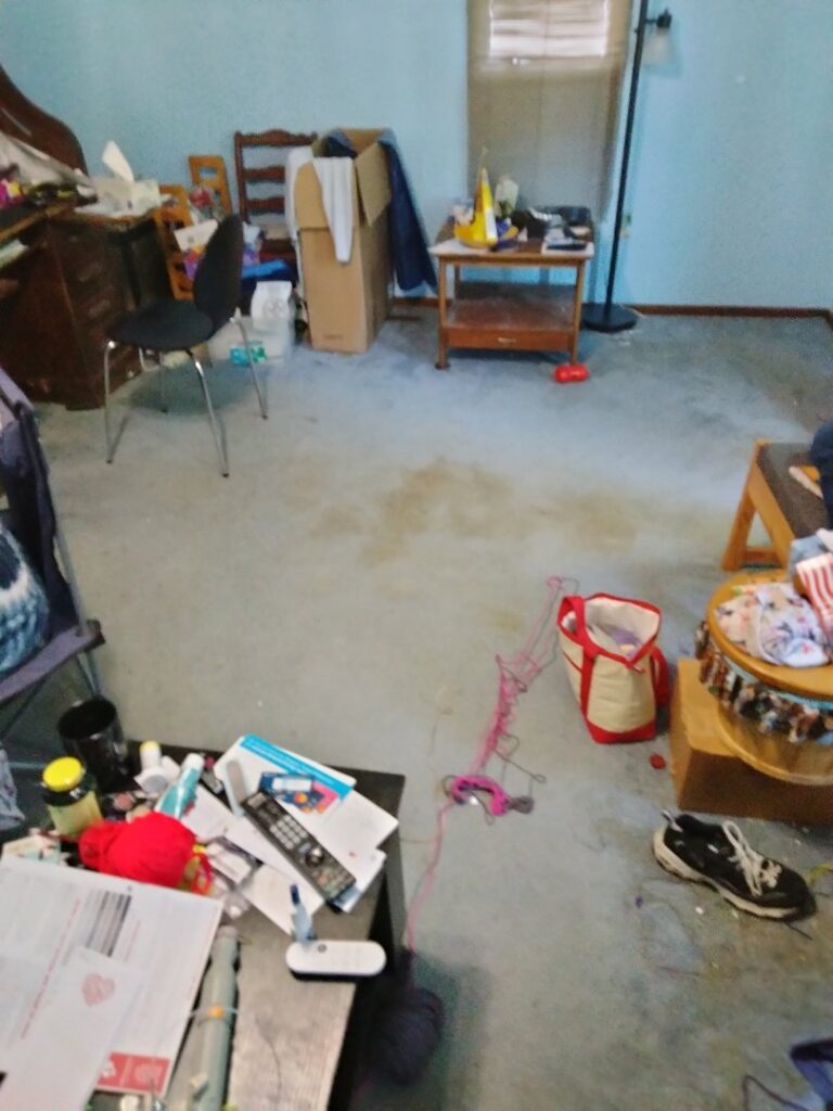 A messy room with various items scattered on the floor, indicating a space requiring a cleanout service from KJ Haul Away Junk Removal in Cedar Rapids, IA.