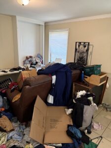 A very messy room filled with clothes, boxes, and furniture, indicating a need for junk removal by Reliable Pro in Tallahassee, FL.