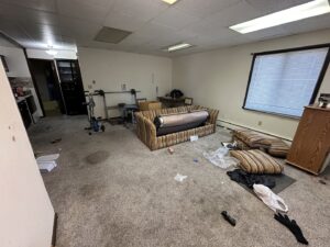 A messy room filled with old furniture, boxes, and debris awaiting removal by Vargas Junk Removal & Dumpster Rentals in Urbandale, IA.
