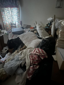 A very messy room filled with clothes and household junk, ready for general junk removal by White Dumpster in Alliance, OH.