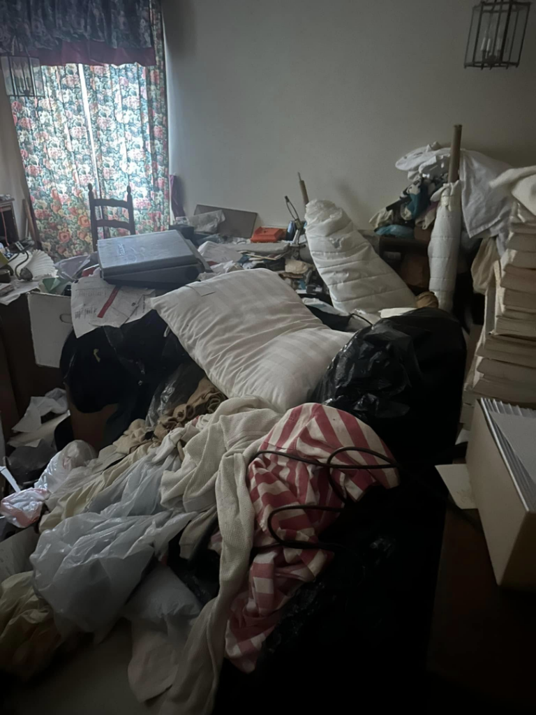 A very messy room filled with clothes and household junk, ready for general junk removal by White Dumpster in Alliance, OH.