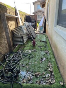 A messy side yard with leaves and debris awaiting junk removal by Impact Environmental Co. in El Cajon, CA.