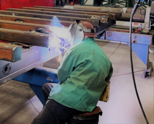 A skilled worker performing metal beam welding for Accurity Industrial Contractors, Inc. in Owensboro, KY