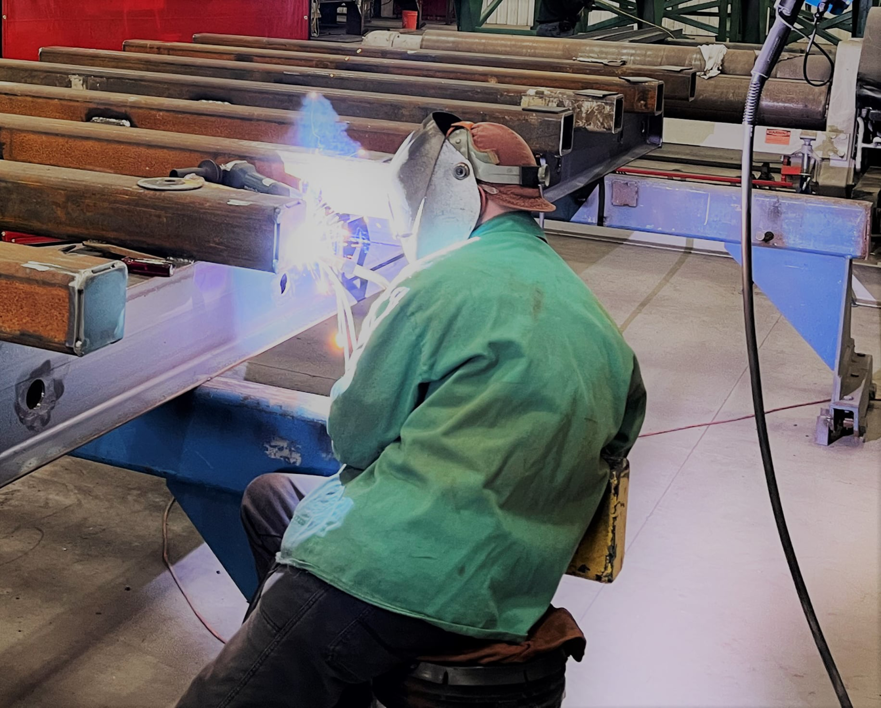 A skilled worker performing metal beam welding for Accurity Industrial Contractors, Inc. in Owensboro, KY
