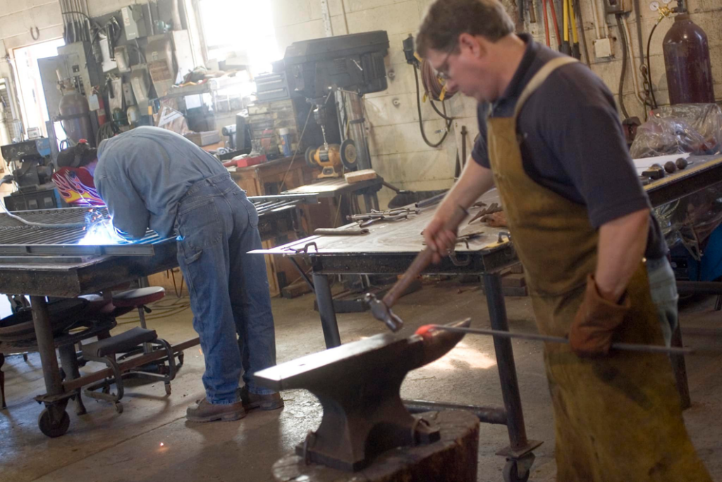 Skilled craftsmen performing metal fabrication, welding, and blacksmithing at Gowan Iron in Montgomery, AL.