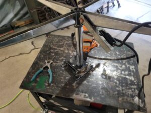 A metal structure being welded on a workbench, showcasing metal fabrication services by Cedar Valley Maintenance and Handyman Services LLC in Waterloo, IA.