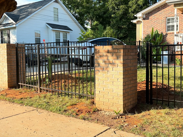New black metal fence with brick pillars installed by BZB Fencing & Staining in Fountain Inn, SC.