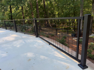 A newly installed black metal grid railing along a concrete patio, completed by HoBart Builders, Inc. in Columbus, GA.
