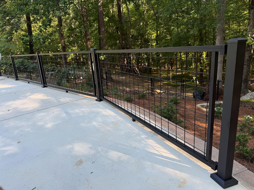 A newly installed black metal grid railing along a concrete patio, completed by HoBart Builders, Inc. in Columbus, GA.