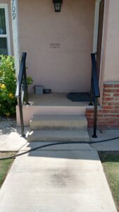 Newly installed black metal handrails on concrete steps by Cal Heights Construction And Handyman Services in Bakersfield, CA