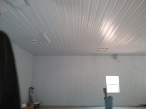 An interior room with white corrugated metal panel walls and ceiling, installed by The House Doctor in Hopkinsville, KY.