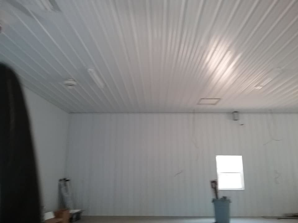 An interior room with white corrugated metal panel walls and ceiling, installed by The House Doctor in Hopkinsville, KY.