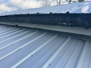 A close-up view of a metal roof and damaged trim, showing potential work for Conway's Roofing in Richmond, KY.