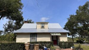 A residential house featuring a new metal roof with a dormer, showcasing a completed project by Hastings Roofing Service Inc. in Orlando, FL.