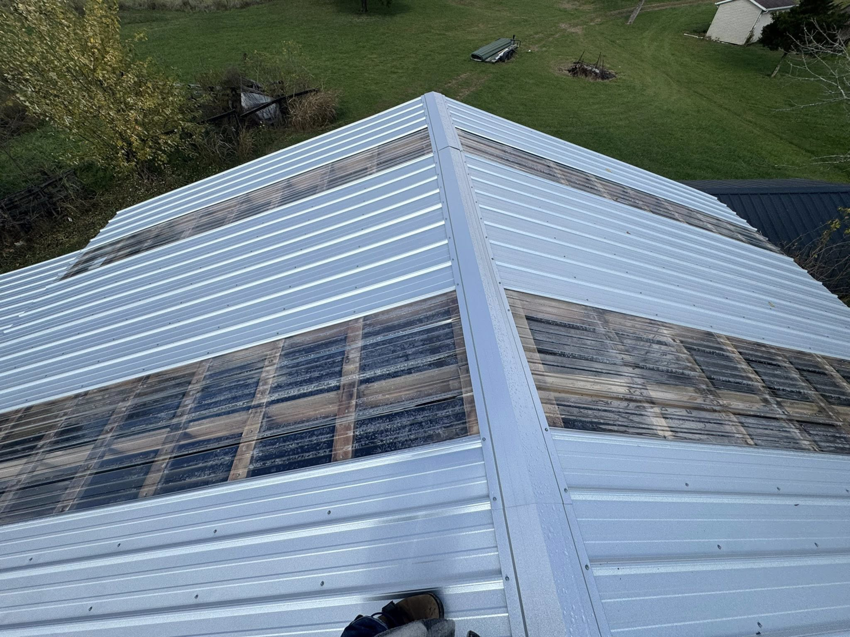 A newly installed metal roof featuring transparent panels, showcasing work by Conway's Roofing in Richmond, KY.