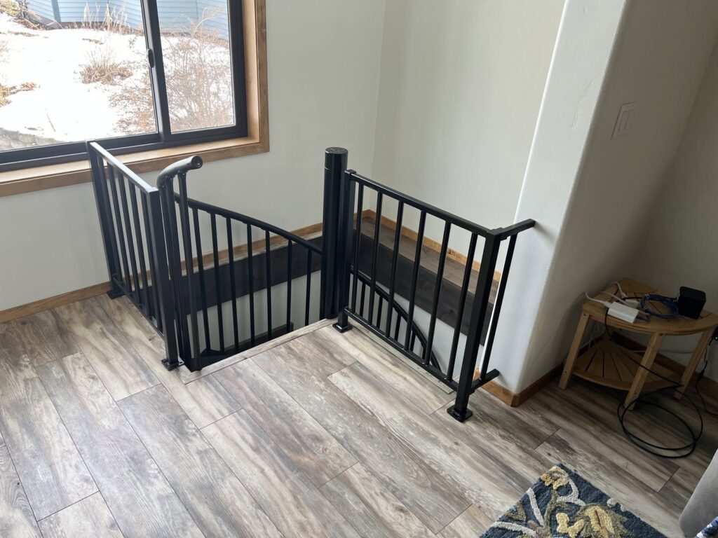 New black metal railings installed around a stairwell opening by 1775 Handyman Services in Kalispell, MT.