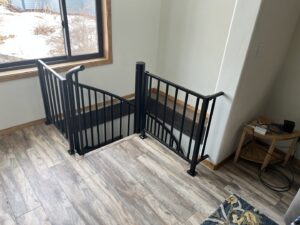 New black metal railings installed around a stairwell opening by 1775 Handyman Services in Kalispell, MT.