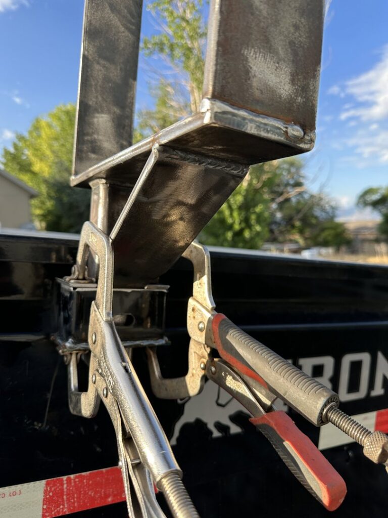 A metal structure held by clamps, showing welding in progress, a custom fabrication service by Jeremy's Welding & Handyman in West Jordan, UT.