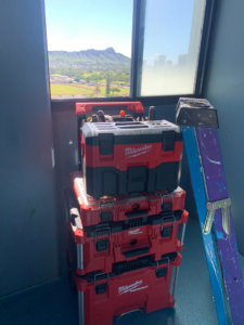 A stack of Milwaukee Packout toolboxes and a ladder ready for a job by Island Handyman in Honolulu, HI.