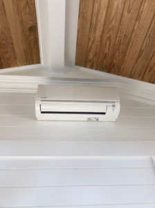 A newly installed mini-split AC unit on a white wall, a service provided by Raleigh Deck & Screen Porch Builder in Raleigh, NC