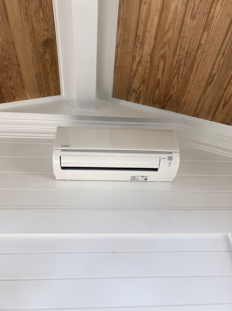A newly installed mini-split AC unit on a white wall, a service provided by Raleigh Deck & Screen Porch Builder in Raleigh, NC