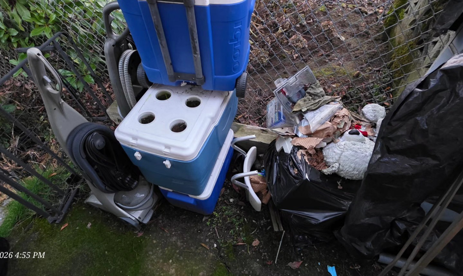 Miscellaneous junk including coolers and a vacuum cleaner ready for removal by Squirrel Squad LLC in Portland, OR.