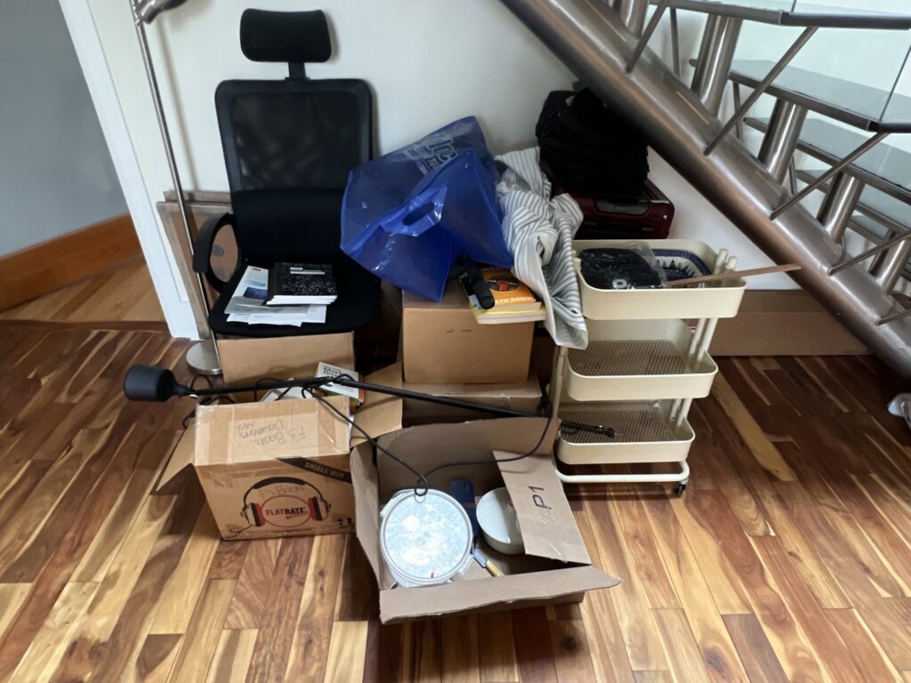 A pile of miscellaneous junk including boxes and an office chair, ready for removal by CleanSite Solutions in Windham, ME.