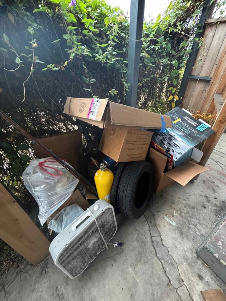 A pile of miscellaneous junk including tires, a fan, and boxes for removal by Elite Hauling & Junk Removal in San Diego, CA.