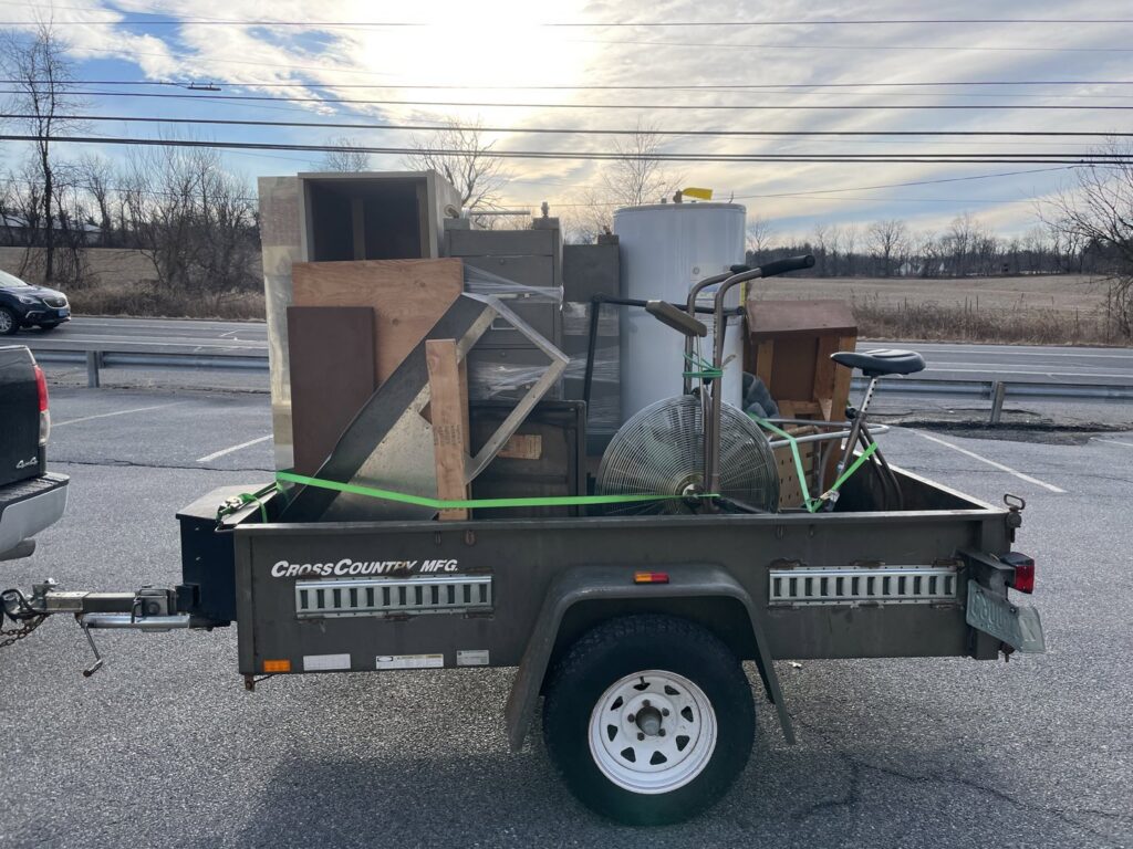 A trailer loaded with miscellaneous junk including a fan and bicycle, for removal by Nu Earth Hauling and Recycling in Allentown, PA.