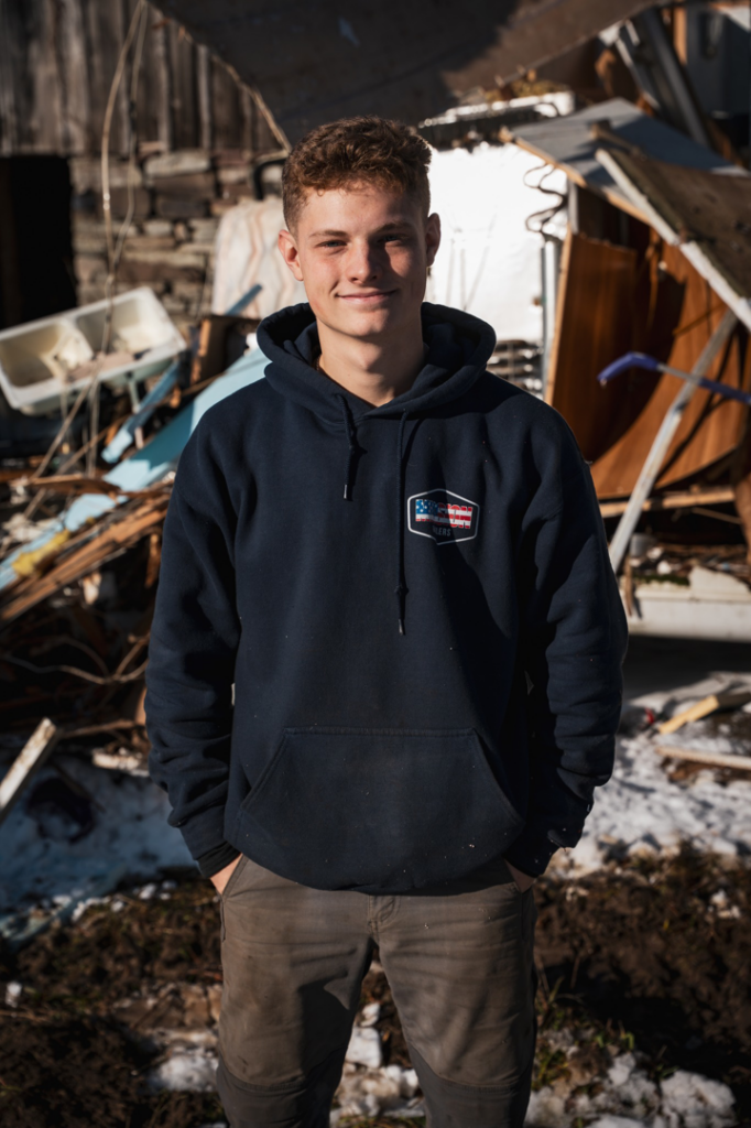 A Mission Haulers employee stands in front of a large pile of debris and junk after a cleanout in Solvay, NY.