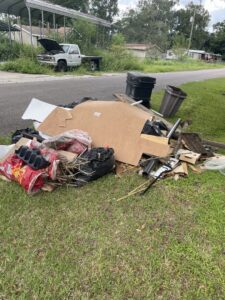 A large pile of mixed junk and debris on a grassy area, ready for removal by Junk Removal JAX in Jacksonville, FL.