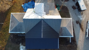 An aerial top-down view of a house with a mixed shingle and metal roof installation by SJL Contracting, LLC in Owensboro, KY.