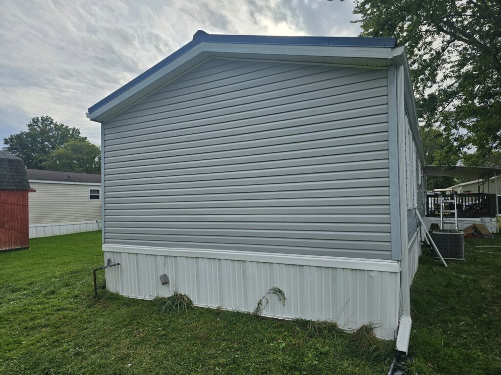 Exterior view of a mobile home with newly installed gray vinyl siding by Ben Nye The Fix-It Guy in Erie, PA.