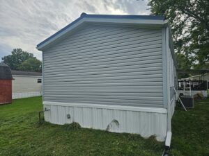 Exterior view of a mobile home with newly installed gray vinyl siding by Ben Nye The Fix-It Guy in Erie, PA.