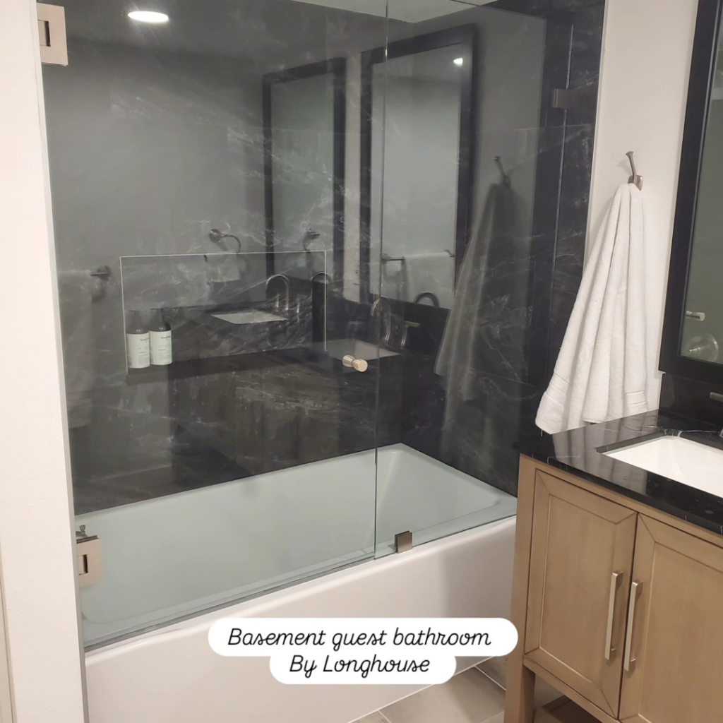 A modern basement guest bathroom featuring a bathtub and glass shower screen, completed by Longhouse Construction Inc. in Estacada, OR.