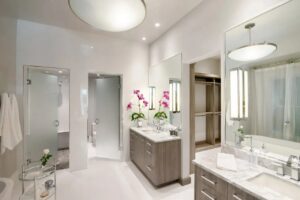 A modern bathroom remodel with a double vanity and glass shower doors by Kornerstone Kitchens in Orlando, FL.