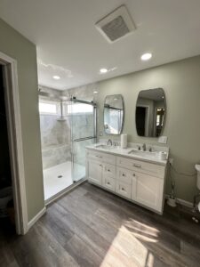 A modern bathroom renovation with a double vanity, walk-in shower, and recessed lighting by Lynden Remodeling in Cincinnati, OH